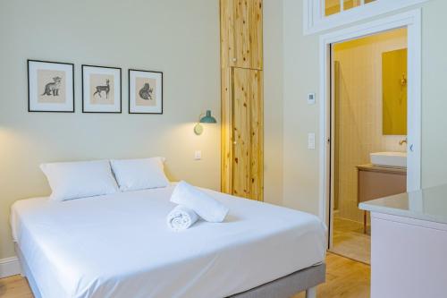 1 Schlafzimmer mit einem weißen Bett und einem Badezimmer in der Unterkunft Majestic Alpin - A luxurious apartment with a nordic feel in Chamonix-Mont-Blanc