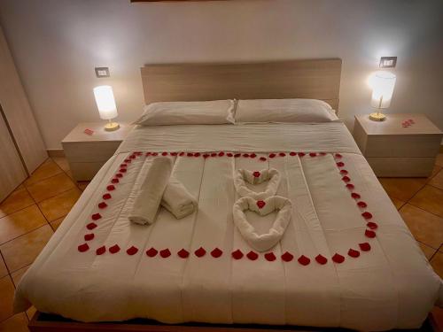 ein Bett mit roten Rosen und zwei Herzen drauf in der Unterkunft All Suite Colosseo in Rom