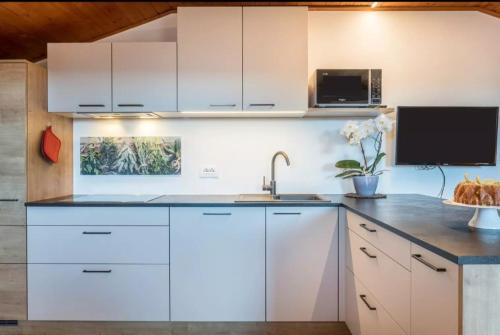 a kitchen with white cabinets and a sink at Gfliererhof in Fiè