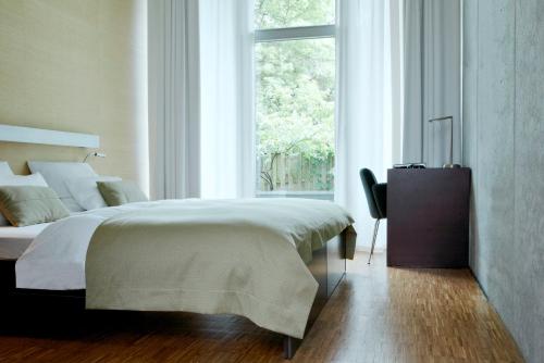 a bedroom with a large bed and a window at Hotel Wedina an der Alster in Hamburg