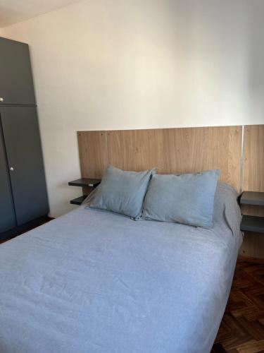 a large bed with blue pillows in a bedroom at Departamento de 1 dormitorio - Zona parque independencia in Rosario