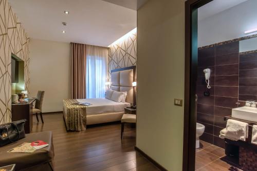 a hotel room with a bed and a bathroom at Catone District Hotel in Rome