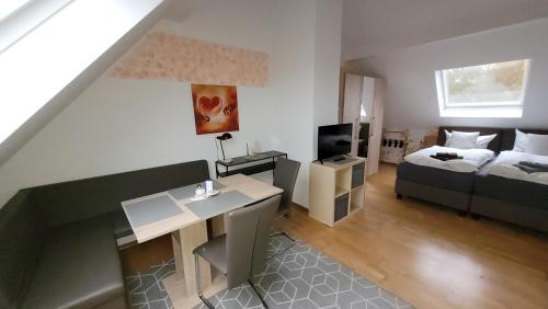 ein kleines Wohnzimmer mit einem Bett und einem Schreibtisch in der Unterkunft Gästehaus Dahmen in Stolberg