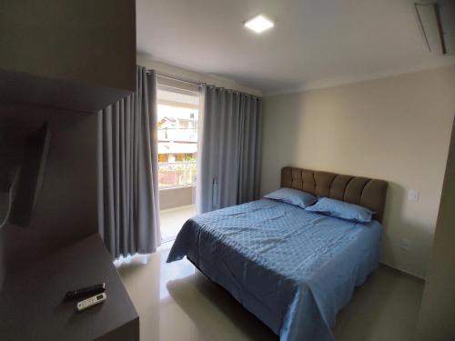 1 dormitorio con cama y ventana grande en Res Mirante 103, en Bombinhas