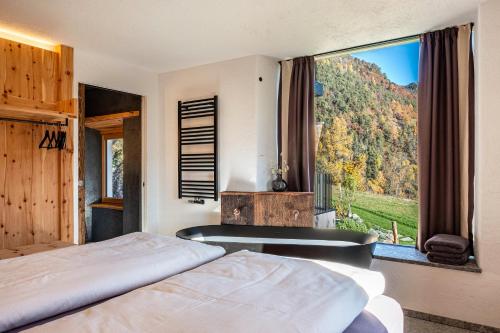 1 dormitorio con 2 camas y ventana grande en Spornberg Mountain Living Ostberg, en Soprabolzano