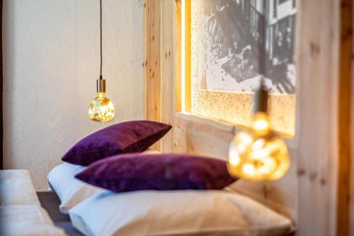 two purple pillows on two beds in a room at Spornberg Mountain Living Ostberg in Soprabolzano
