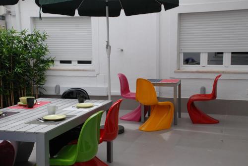 a patio with a table and chairs with an umbrella at StayInn City - Évora in Évora