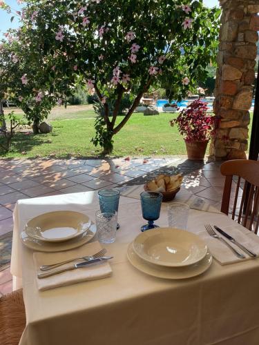 a table with plates and silverware on top of it at Hotel Janas in Tertenìa