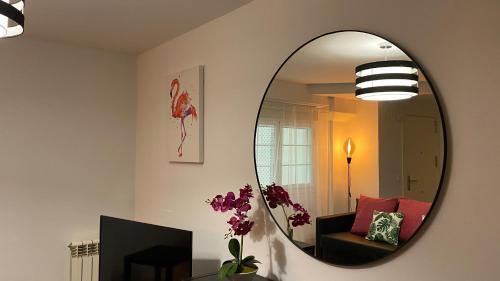 sala de estar con espejo en la pared en LC Apartamentos César Augusto en Zaragoza