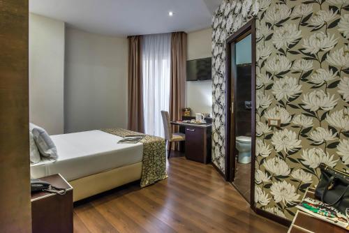 a hotel room with a bed and a bathroom at Catone District Hotel in Rome