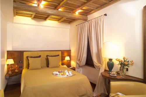 a bedroom with a bed and a table with a plate on it at Locanda dello Spuntino in Grottaferrata