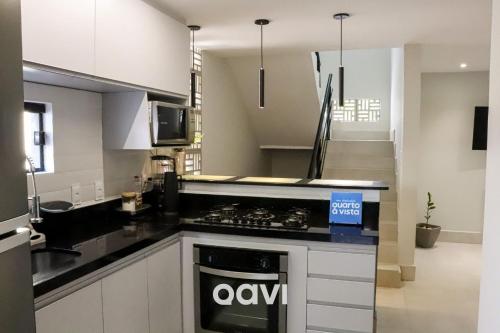 uma cozinha com bancadas pretas e um forno com placa de fogão em Qavi - Casa fantástica no condomínio Vista Hermosa #CasaNanu09 em Pipa