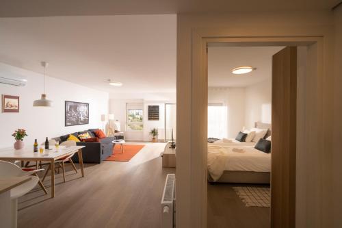 een slaapkamer en een woonkamer met een bed en een tafel bij Mannequin: Sea view, private parking in the garage in Rijeka