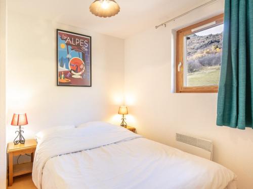 1 dormitorio con cama y ventana en Les Grizzlis - 31 - Accueillant Duplex - 8 pers en Saint-Sorlin-dʼArves