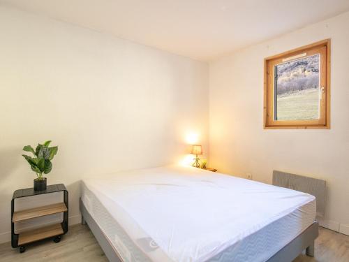 a bedroom with a large white bed and a window at Les Grizzlis - 22 - Appart montagne PMR - 4 pers in Saint-Sorlin-dʼArves