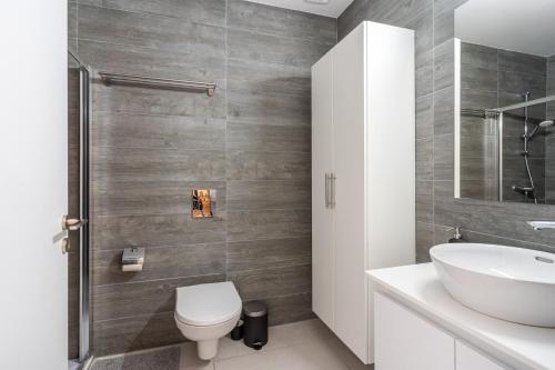 a bathroom with a white toilet and a sink at Sunshine 1-Bedroom Apartment in Larnaca in Larnaka