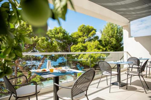 a patio with tables and chairs on a balcony at TUI BLUE Makarska - Adults Only in Igrane