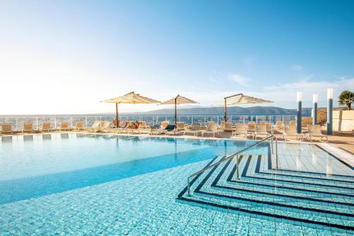 uma grande piscina com cadeiras e guarda-sóis em TUI BLUE Makarska - Adults Only em Igrane