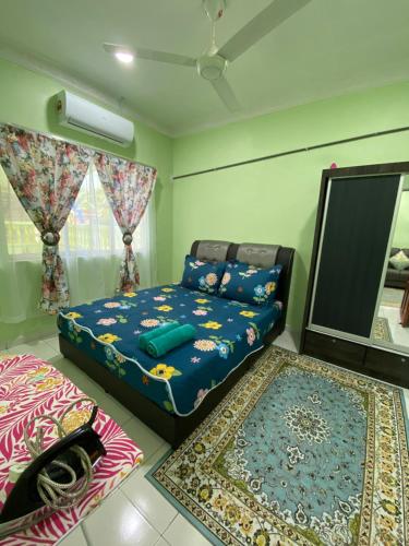 a bedroom with a bed and a mirror and rugs at Green Home Homestay Melaka in Masjid Tanah