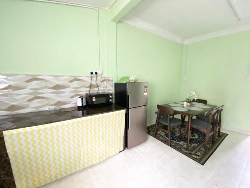 a kitchen with a refrigerator and a small table at Green Home Homestay Melaka in Masjid Tanah