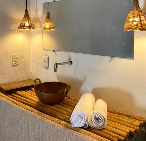 ein Badezimmer mit einem hölzernen Waschbecken und zwei gewalzten Handtüchern in der Unterkunft Quintal do Céu Caraíva in Porto Seguro