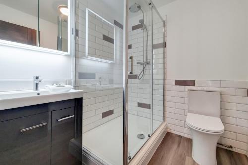 a bathroom with a shower and a toilet and a sink at Roomspace Serviced Apartments - Brewers Lane in Richmond