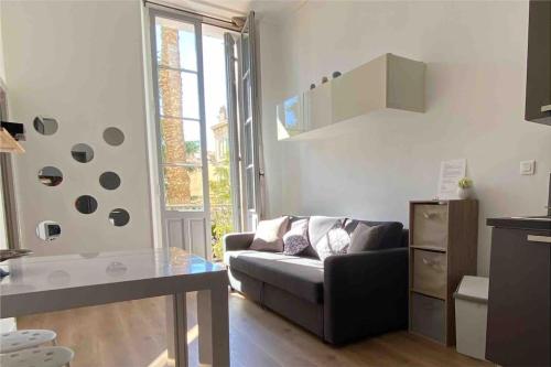 un salon avec un canapé et une table dans l'établissement Joli appartement à 5 minutes du palais et plages, à Cannes