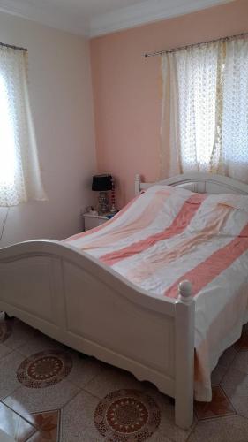 a large white bed in a room with windows at flowerhouse Sukuta Gambia in Sukuta
