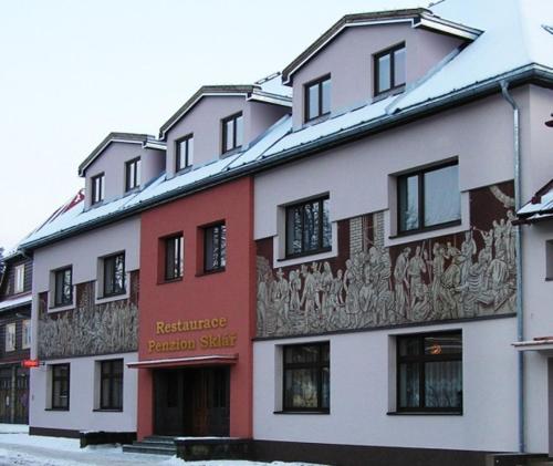 a building with a painting on the side of it at Penzion a restaurace Sklář in Karolinka