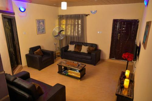 a living room with couches and a coffee table at Living Green APARTMENTS AIRPORT PICK UP in Benin City