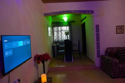 a living room with a green and purple wall at Living Green APARTMENTS AIRPORT PICK UP in Benin City