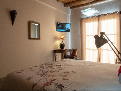 ein Schlafzimmer mit einem Bett, einer Lampe und einem Fenster in der Unterkunft Tigmi Anis in Essaouira