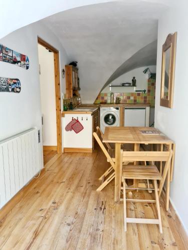 une cuisine avec une table et des chaises dans une pièce dans l'établissement Le Préau, à Ornon