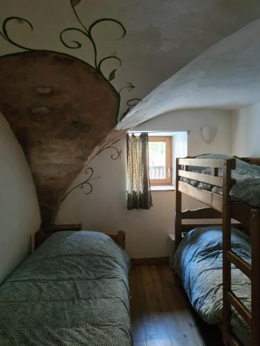 une chambre avec deux lits superposés et une fenêtre dans l'établissement Le Préau, à Ornon