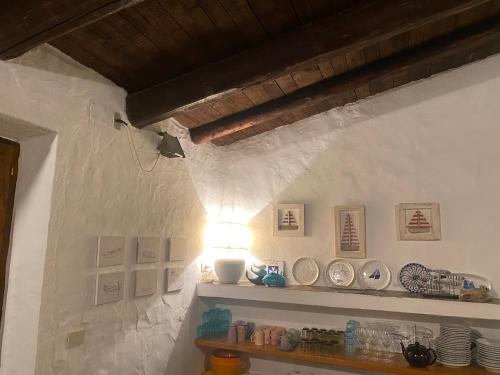 una stanza con una mensola con piatti e una luce di Villa Grace a La Maddalena