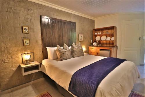 a bedroom with a large bed with two night stands at The Ranch Guesthouse in Potchefstroom