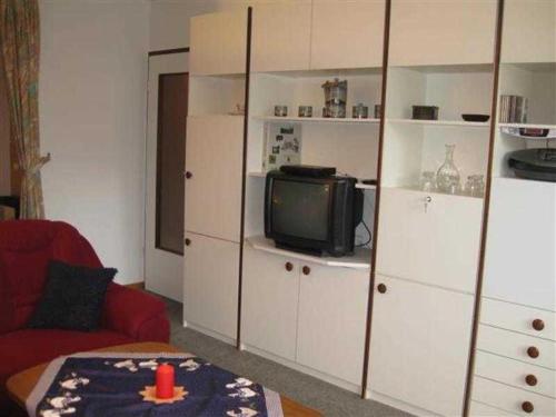 sala de estar con TV y armarios blancos en Ferienwohnung Klingelhöfer E-III-2-6, en Altenau