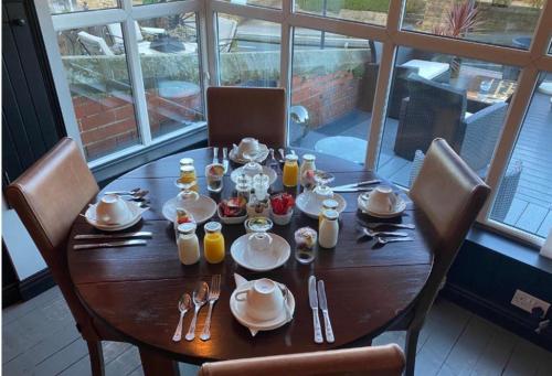 una mesa de madera con platos y utensilios. en The Wayfarer, Robin Hoods Bay, en Whitby