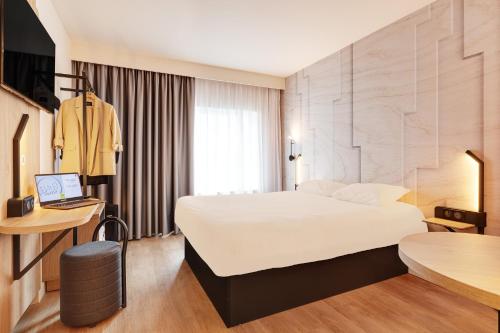 Un pat sau paturi într-o cameră la B&B HOTEL Lille Lillenium Eurasanté