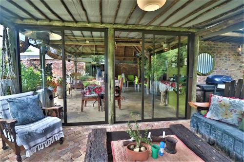 a patio with glass doors and a couch and a table at The Ranch Guesthouse in Potchefstroom
