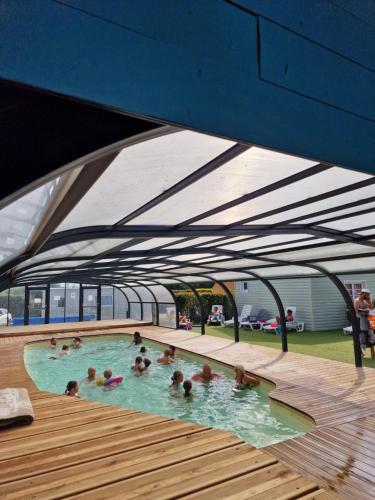 un groupe de personnes nageant dans une piscine dans l'établissement Gîtes Les P'tites Maisons dans la Prairie, à Sallertaine