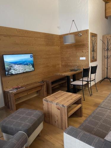 a living room with a table and a flat screen tv at Chalet Jasná Apartment Franco jacuzzi & sauna in Demanovska Dolina