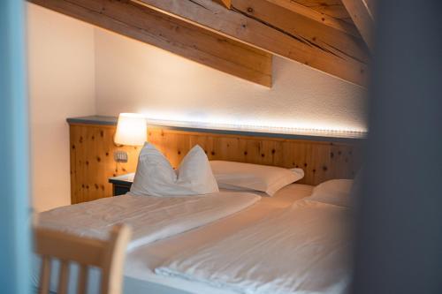 a bedroom with two beds with a wooden wall at La Roccia Wellness Hotel in Cavalese