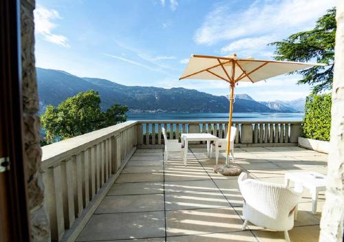 a white umbrella sitting on top of a wooden bench at Villa Lario Resort Mandello in Mandello del Lario