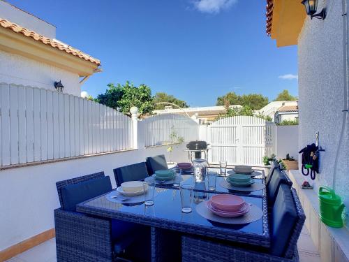 a blue table with chairs and plates on a patio at Butterfly Bungalow - 9009 in Los Alcázares