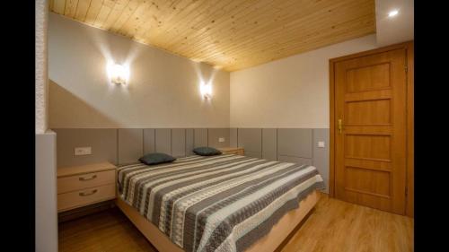 Schlafzimmer mit einem Bett und einer Holztür in der Unterkunft White House in Truskawez