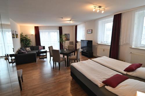 a hotel room with two beds and a dining room at Pension am Schloss in Schwerin