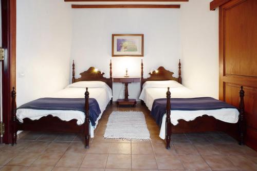a bedroom with two beds and a table in it at Casa De La Eterna Primavera in San Bartolomé