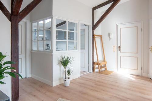 an open living room with white walls and wooden floors at smør I Skandi-Style im Speicher I 1 Min zum Hafen in Husum