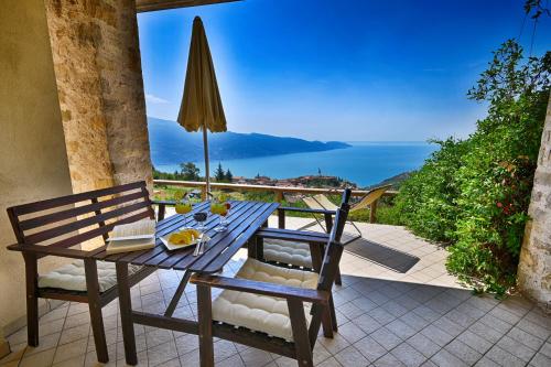 a table and chairs on a patio with a view of the ocean at BnB Borgo le Vigne - L'Uva rara Only Adults in Tignale